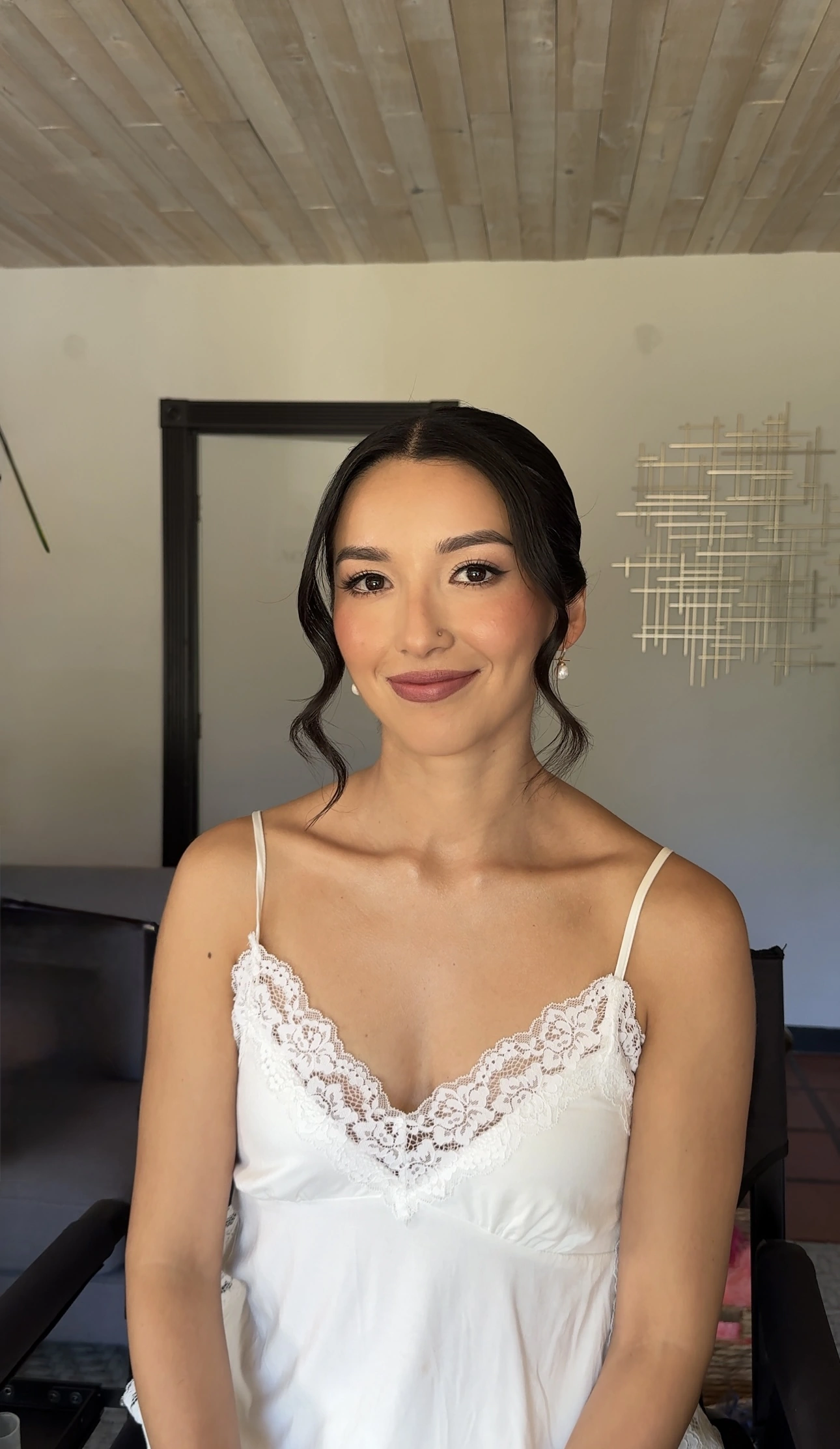 Soft bridal makeup with rose-toned lips and a romantic updo