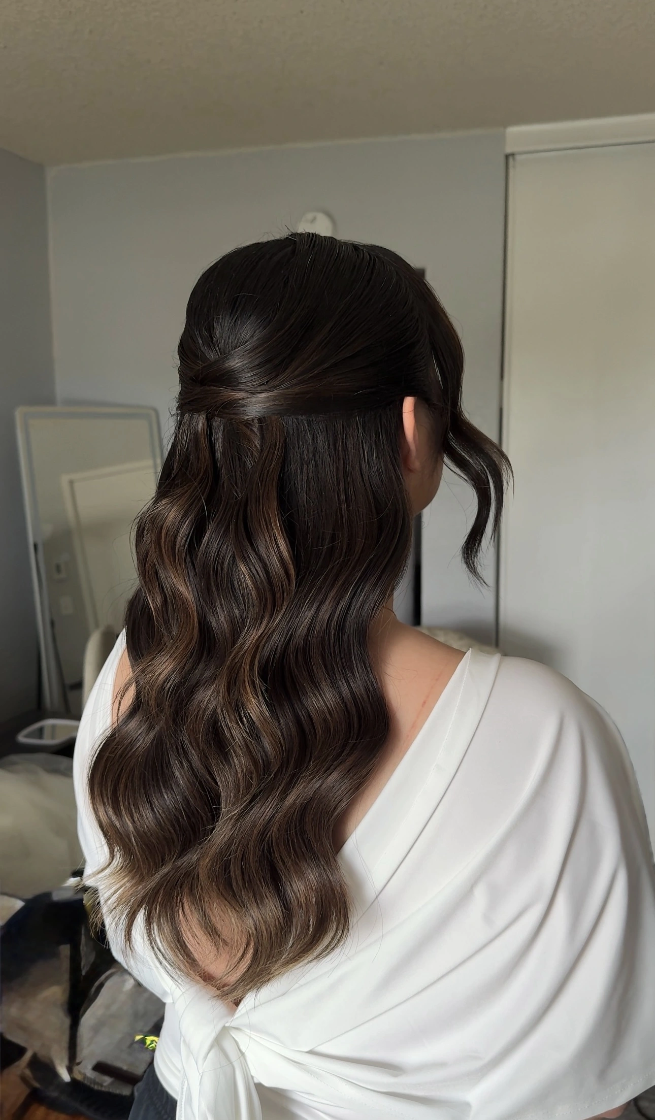 Brunette half-up hairstyle with sculpted waves