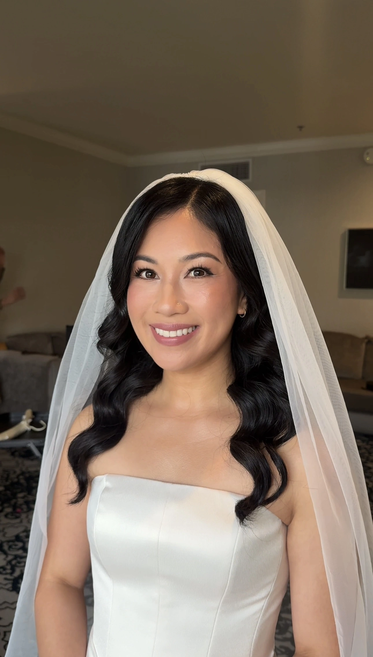 Bride in a veil with luminous makeup and glossy waves