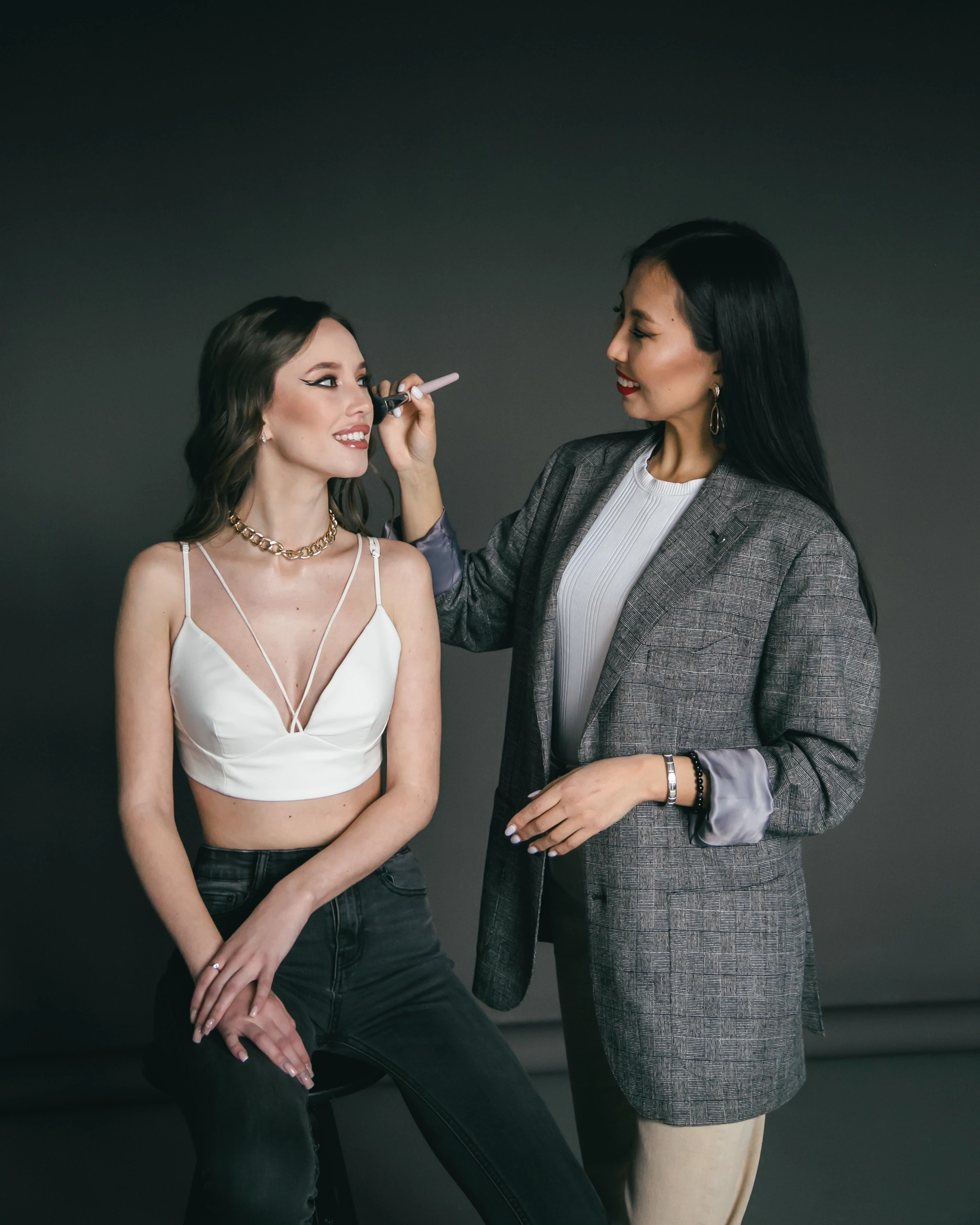 The makeup artist applying a finishing touch to luminous makeup in a studio