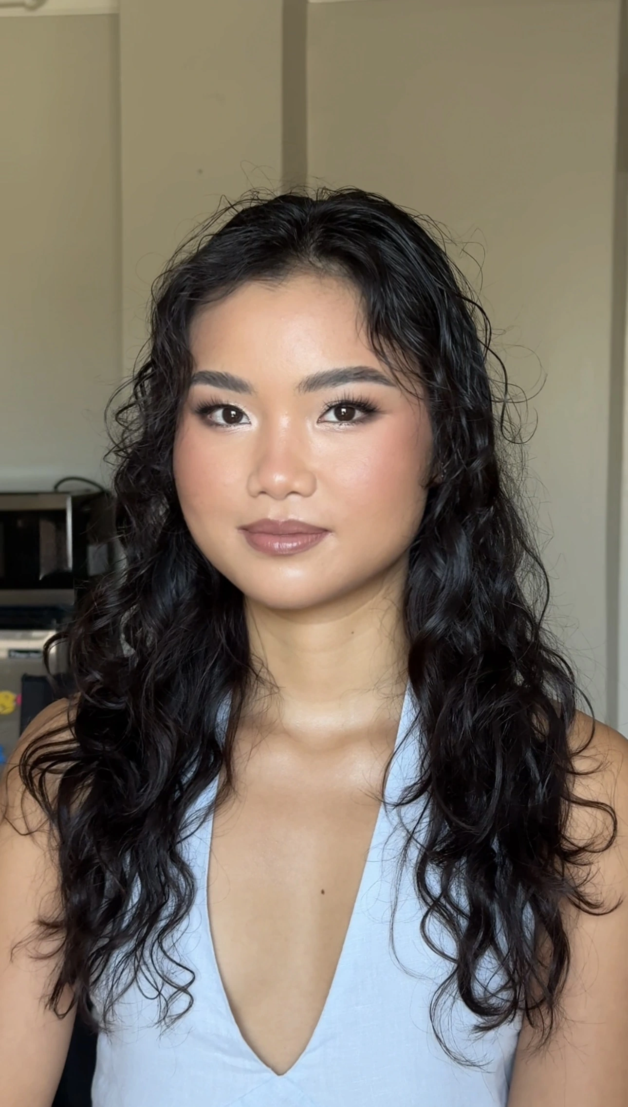 Glowing makeup with defined lashes and natural curls